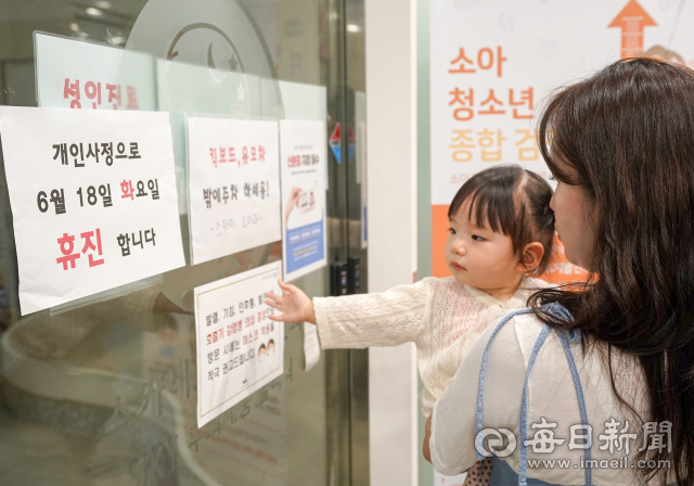 전국 병의원들이 집단 휴진에 들어가기로 한 18일 대구의 한 소아청소년과 의원 앞에서 아이와 엄마가 휴진을 알리는 안내문을 보고 발걸음을 돌리고 있다. 아이 엄마는 