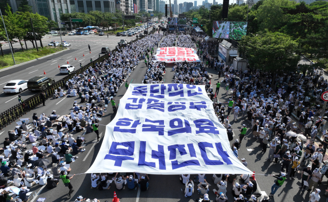 대한의사협회(의협)의 주도로 개원의와 일부 의대 교수들이 집단휴진에 나선 18일 오후 서울 영등포구 여의대로에서 열린 전국 의사 총궐기대회에서 의사들이 