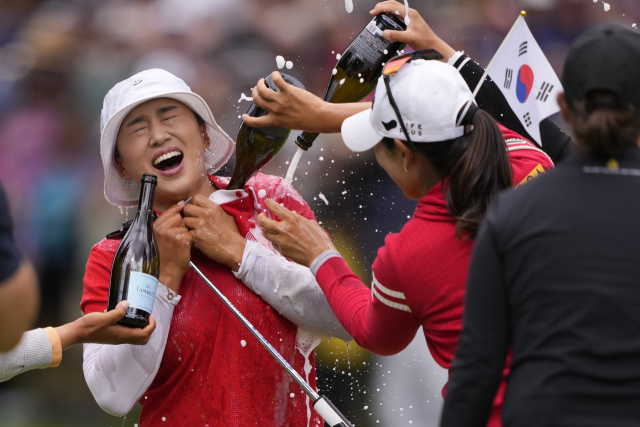 양희영이 23일(현지시간) 미국 워싱턴주 사할리 컨트리클럽에서 열린 미국 여자프로골프(LPGA) KPMG 여자 PGA 챔피언십에서 우승해 트로피를 들어 보이고 있다. 동료 선수들이 샴페인을 부으며 축하해 주고 있다. 연합뉴스