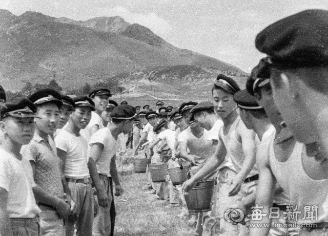 1962년 6월 26일 대구고 학생들이 앞산 고산골 자락 다랑논 묘판에 물을 주기 위해 신천 용두방천에서 릴레이로 물통을 나르고 있다. 사진=매일아카이빙센터