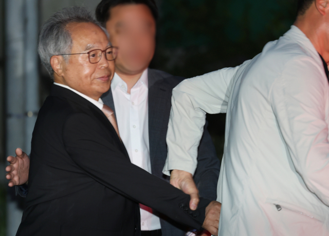 직원을 강제 추행한 혐의로 징역 3년을 선고받은 오거돈 전 부산시장이 26일 오전 만기 출소로 풀려나 부산 사상구 부산구치소를 나서고 있다. 취재진 질문이 이어지자 오 전 시장의 지인은 그의 손을 이끌고 차량에 빠르게 태웠다. 연합뉴스