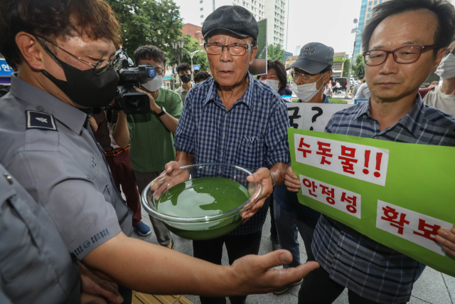 2022년 8월 대구시청 앞에서 매곡취수장 인근에서 퍼온 낙동강 물을 대구시장에게 전달하려는 환경단체 회원들과 청원경찰이 대치하고 있다. 매일신문DB