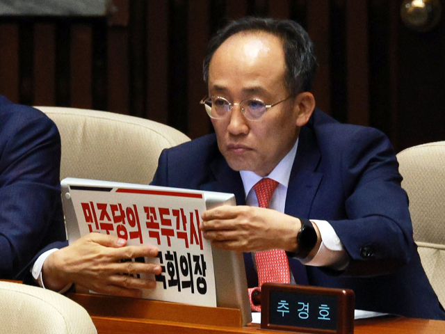 2일 국회에서 열린 본회의에서 국민의힘 추경호 원내대표가 입장하며 자리에 피켓을 붙이고 있다. 연합뉴스