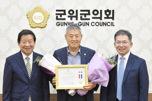 대구 군위군의회 박운표(가운데) 의원이 지방의정봉사상을 수상하고, 김진열(오른쪽) 군위군수, 최규종(왼쪽) 군의회 의장과 기념 사진을 촬영하고 있다. 군위군의회 제공