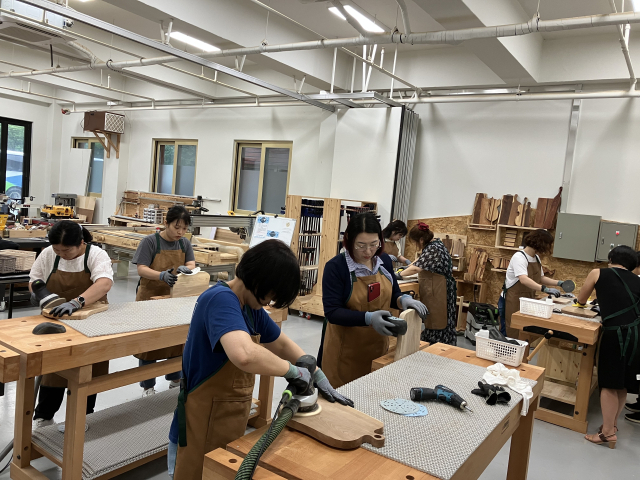 봉화를 찾은 관광객들이 목재문화체험장에서 도마만들기 체험을 하고 있다. 봉화군 제공