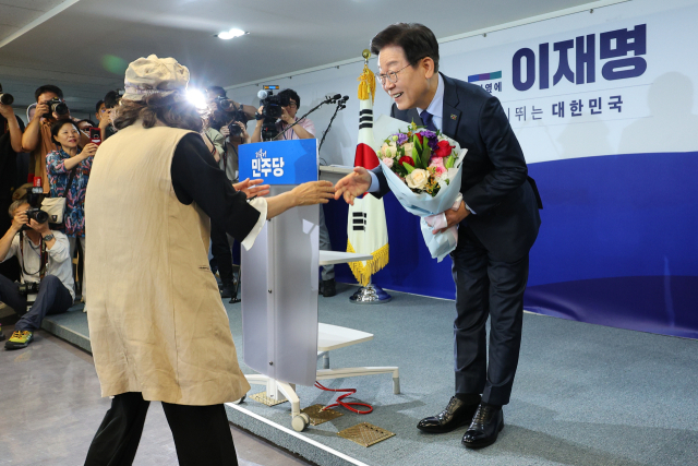 더불어민주당 이재명 전 대표가 10일 오전 서울 여의도 중앙당사에서 열린 당 대표 출마 선언 기자회견에서 꽃다발을 받고 있다. 연합뉴스