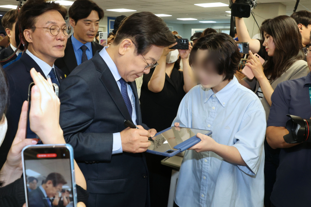 더불어민주당 이재명 전 대표가 10일 오전 서울 여의도 중앙당사에서 당 대표 출마 선언을 하기에 앞서 지지자에게 사인을 해주고 있다. 연합뉴스