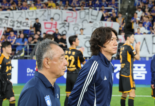 10일 오후 울산 문수축구경기장에서 축구 국가대표팀 감독으로 내정된 울산 HD 홍명보 감독이 광주FC와의 경기 후 자신을 비판하는 걸개가 내걸린 서포터스석 옆을 지나가고 있다. 연합뉴스