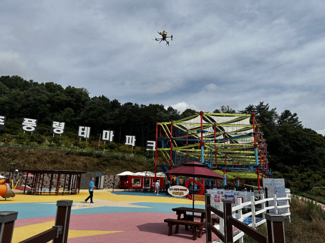 추풍령휴게소 먹거리를 추풍령테마파크로 배송하는 드론배달서비스의 본격 시행을 앞두고 관계자들이 드론 배송 시험을 하고 있다. 김천시시설관리공단 제공