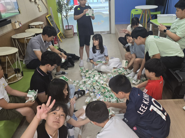 안동시 풍천면 신성초등학교 학생들이 씻어 말린 유유팩을 뜯어 펼쳐 재활용 할 수 있도록 부피를 줄이는 작업을 하고 있다. 신성초 제공
