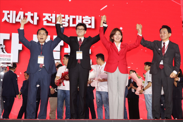 국민의힘 한동훈 당 대표 당선자가 23일 오후 경기도 고양시 킨텍스에서 열린 국민의힘 제4차 전당대회에서 개표결과 발표 후 경쟁자였던 윤상현, 나경원, 원희룡 후보와 손을 들어 올리고 있다. 연합뉴스
