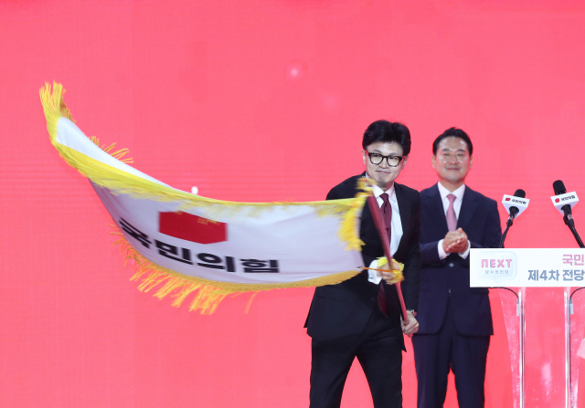 국민의힘 한동훈 신임 당 대표가 23일 경기 고양 킨텍스에서 열린 제4차 국민의힘 전당대회에서 당대표로 선출된 뒤 당기를 흔들고 있다. 연합뉴스