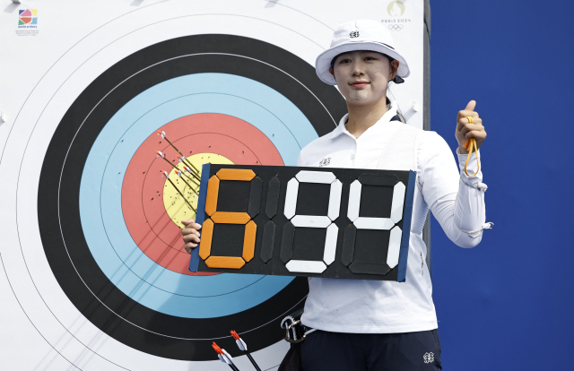 25일(현지시간) 프랑스 파리 레쟁발리드에 마련된 양궁 경기장에서 열린 2024 파리올림픽 여자 개인전 랭킹 라운드에서 임시현이 694점으로 세계신기록을 세운 뒤 점수판을 들고 기념 촬영하고 있다. 연합뉴스