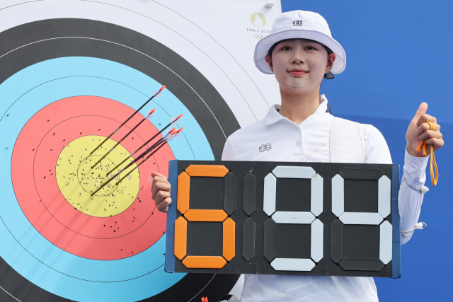 25일(현지시간) 프랑스 파리 레쟁발리드에 마련된 양궁 경기장에서 열린 2024 파리올림픽 양궁 여자 개인전 랭킹 라운드에서 총점 694점을 기록하며 세계 신기록을 달성한 임시현이 자신의 과녁 앞에서 기념촬영하고 있다. 연합뉴스