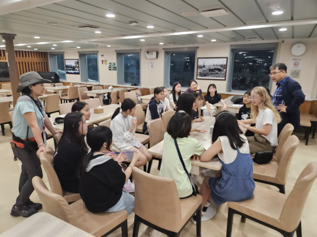 서울시강서양천교육지원청 초교 6학년 자치활동 임원 학생들이 울릉크루즈 대형 여객선 뉴시다오펄호 연회장에서 외국인 유학생과 토론을 하고 있다. 울릉크루즈 제공.