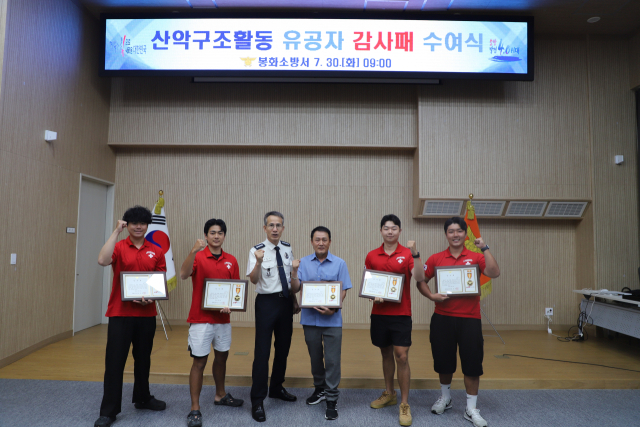 유공감사패를 전달 받은 강변레프팅 직원들과 소방관계자들이 파이팅을 외치고 있다. 봉화소방서 제공