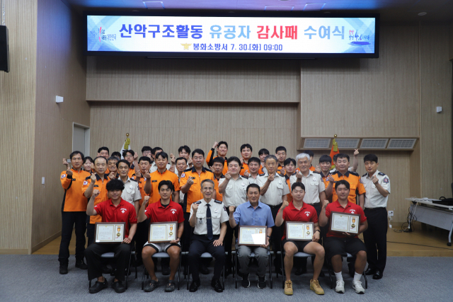 유공감사패를 전달 받은 강변레프팅 직원들과 소방관계자들이 파이팅을 외치고 있다. 봉화소방서 제공