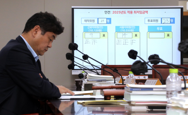 최저임금위원회는 12일 새벽 정부세종청사에서 열린 제11차 전원회의에서 투표를 거쳐 내년 최저임금을 시간당 1만30원으로 결정했다. 이는 올해보다 1.7% 오른 것으로, 사상 처음으로 최저임금 1만원 시대를 맞게 됐다. 사진은 회의가 끝난 뒤 이인재 최저임금위원장이 자리에서 생각에 잠겨 있다. 연합뉴스