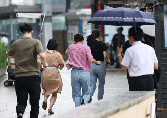 지난 5일 서울 중구 한국은행 앞 사거리에서 시민들이 소나기를 피하고 있다. 연합뉴스