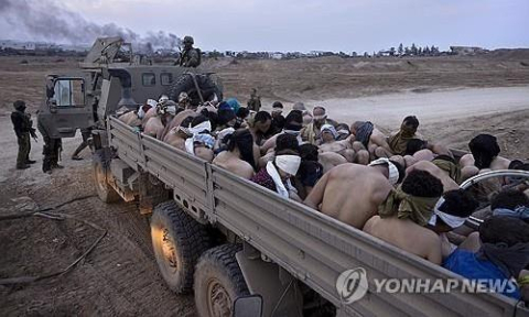 이스라엘군에 끌려가는 팔레스타인 수감자들. AP=연합뉴스