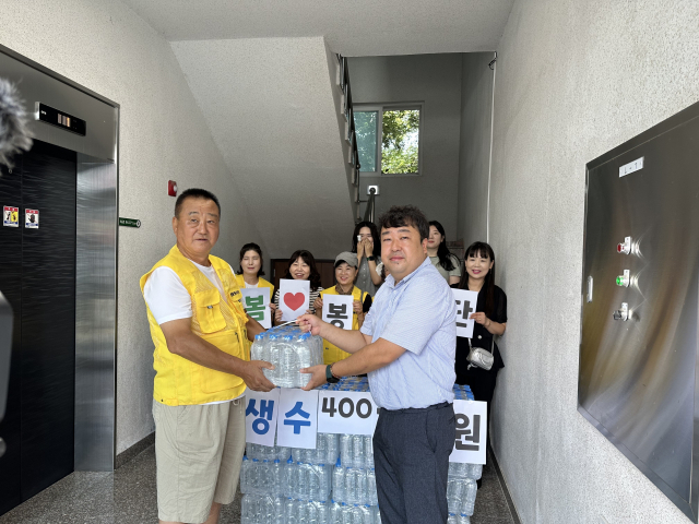 최종학(왼쪽) 돌봄봉사단장이 생수를 전달하고 있다. 독자 제공