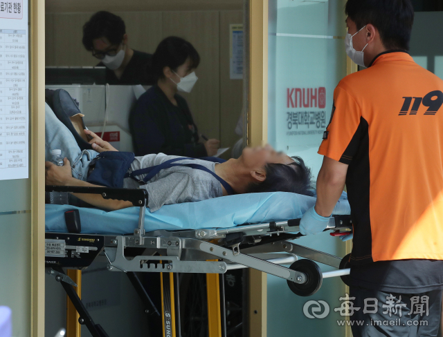 대구에 폭염경보가 이어진 7일 오후 119구급대원들이 온열 질환자를 중구 경북대병원 대구권역응급의료센터로 이송하고 있다. 정운철 기자 woon@imaeil.com