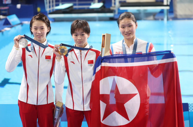 6일(현지시간) 프랑스 파리 아쿠아틱센터에서 열린 2024 파리올림픽 다이빙 여자 10ｍ 플랫폼 결승에서 동메달을 딴 북한 김미래가 인공기를 펼친 채 중국 메달리스트들과 함께 포즈를 취하고 있다. 연합뉴스