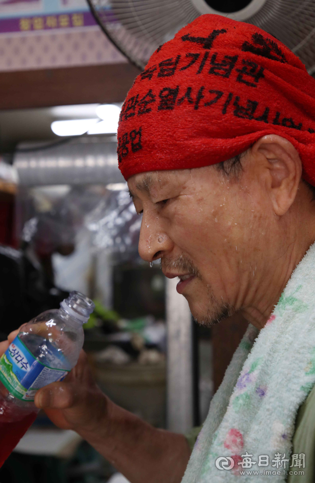폭염이 계속된 9일 오후 대구 남구 봉덕시장에서 한 떡집 상인이 선풍기 앞에서 땀을 식히며 무더위를 달래고 있다. 정운철 기자 woon@imaeil.com