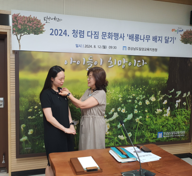 김정희 교육장(사진 우측)이 7월 1일자로 공직생활을 시작하는 김혜진 주무관에서 청렴을 상징하는 배롱나무 배지를 달아주고 있다. 밀양교육지원청 제공