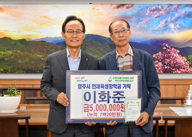 이화준 전 영주시 자치안전국장(오른쪽)이 박남서 영주시인재육성장학회 이사장에게 장학금을 전달하고 있다. 영주시 제공