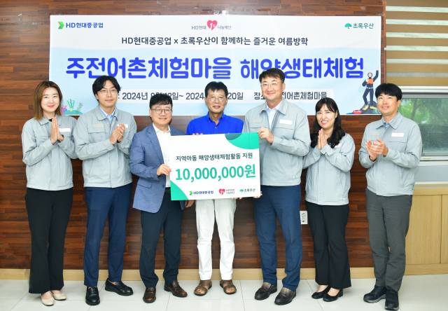 HD현대1%나눔재단과 HD현대중공업 관계자들이 20일 울산 동구 주전어촌체험마을에서 초록우산어린이재단에 아동 생태체험활동 지원금 1000만원을 기탁하고 있다. [사진=HD현대중공업]