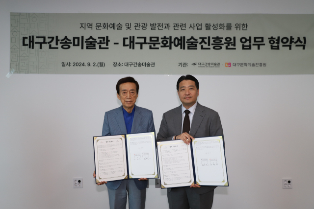 김정길(왼쪽) 대구문화예술진흥원 원장과 전인건 대구간송미술관 관장이 업무협약서를 들어보이고 있다. 대구문화예술진흥원 제공