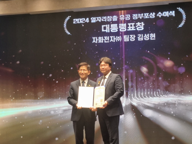 김성현(오른쪽) 구미 자화전자 노사협력팀장이 지난 5일 김문수 고용노동부 장관으로부터 대통령 표챵을 받은 뒤 사진을 찍고 있다. 자화전자 제공