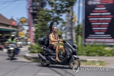 발리 관광객 발리를 찾은 한 관광객이 상의를 탈의한 채 헬멧도 없이 오토바이를 타고 있다. EPA=연합뉴스