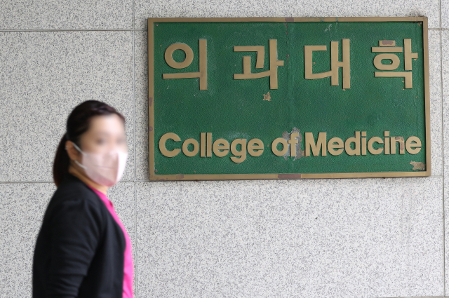 2학기 전국 40개 의과대학의 등록률이 3.4%인 것으로 나타났다. 지난 2일 기준 전국 40개 의대 1만9천374명 중 2학기 등록금을 납부한 인원은 653명에 그쳤다. 사진은 22일 오전 서울 시내 한 의과대학에서 한 시민이 의과대학 간판을 지나치고 있다. 연합뉴스