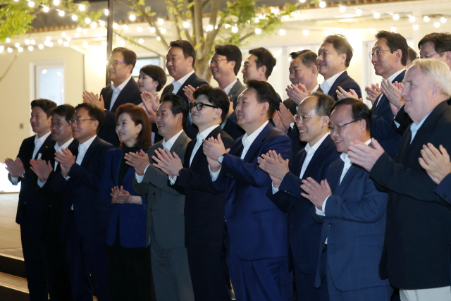 윤석열 대통령이 24일 서울 용산 대통령실 앞 분수정원에서 열린 국민의힘 지도부 초청 만찬 뒤 한동훈 대표, 추경호 원내대표 등 국민의힘 지도부, 대통령실 참모진과 함께 기념 촬영을 하고 있다. 연합뉴스