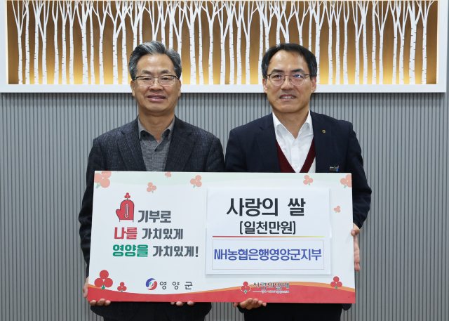 장문섭 NH농협은행 영양군지부장(오른쪽)이 지난 26일 영양군청에서 오도창 영양군수를 만나 지역 주민을 위한 사랑의 쌀을 기부하고 기념 촬영하고 있다. 영양군 제공