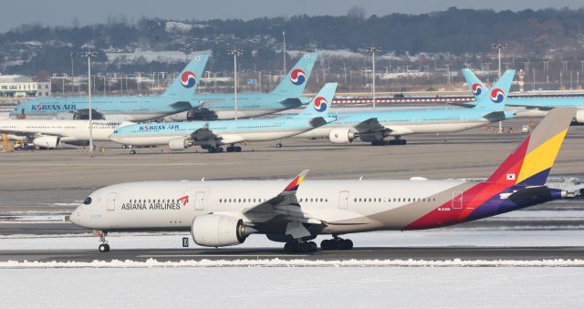 지난달 28일 인천 영종도 인천국제공항 활주로와 주기장에 대한항공-아시아나항공 여객기가 보이고 있다. 유럽연합 집행위원회는 28일(현지시간) 대한항공과 아시아나항공의 결합을 최종 승인했다. 연합뉴스