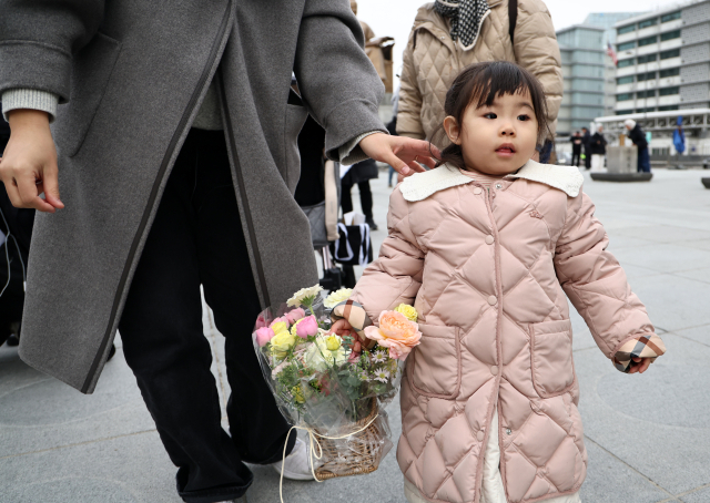 국내에는 치료법이 없는 희귀병을 앓고 있는 네 살 딸의 치료비용을 위해 전국 곳곳을 돌며 후원을 요청하고 있는 전요셉 씨의 가족 이상아씨와 사랑이가 29일 오후 서울 광화문광장에 도착하는 전 씨에게 향하고 있다. 연합뉴스