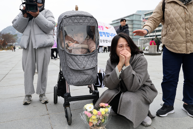 국내에는 치료법이 없는 희귀병을 앓고 있는 네 살 딸의 치료비용을 위해 전국 곳곳을 돌며 후원을 요청하고 있는 전요셉 씨의 가족 이상아씨와 사랑이가 29일 오후 서울 광화문광장에 도착하는 전 씨를 기다리고 있다. 연합뉴스