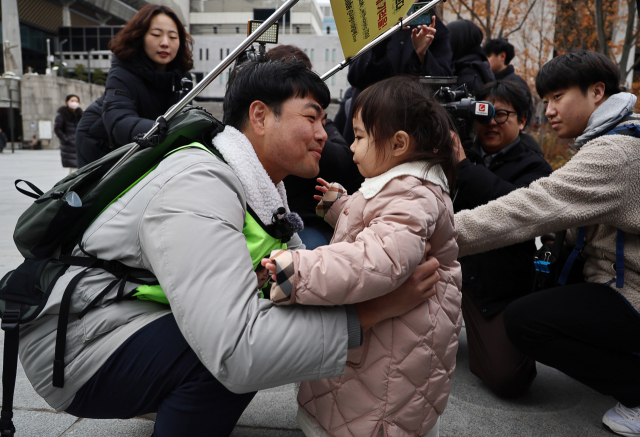 국내에는 치료법이 없는 희귀병을 앓고 있는 네 살 딸 사랑이의 치료비용을 위해 전국 곳곳을 돌며 후원을 요청하고 있는 전요셉 씨가 29일 오후 최종 목적지인 서울 광화문광장에 도착, 마중 나온 사랑이를 안고 있다. 연합뉴스