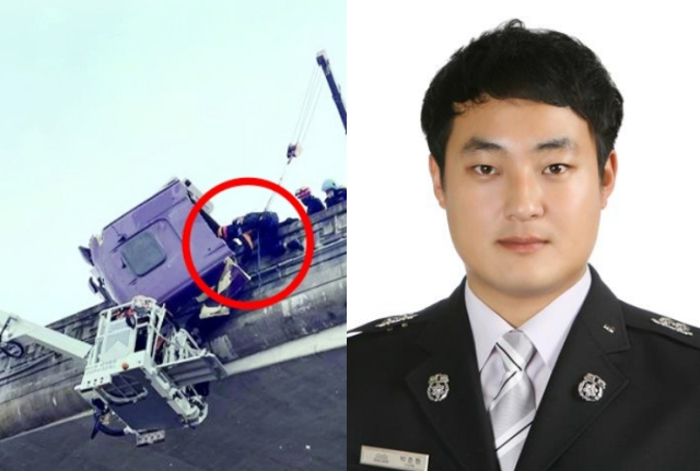 27일 경북 안동시 풍산읍 계평리 중앙고속도로에서 눈길에 미끄러져 난간과 충돌한 대형 트레일러 차량의 운전자를 박준현 소방교(오른쪽)가 맨손으로 붙잡고 있다. 경북소방본부 제공
