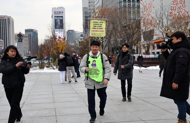 국내에는 치료법이 없는 희귀병을 앓고 있는 네 살 딸 사랑이의 치료비용을 위해 전국 곳곳을 돌며 후원을 요청하고 있는 전요셉 씨가 29일 오후 최종 목적지인 서울 광화문광장으로 들어서고 있다. 연합뉴스