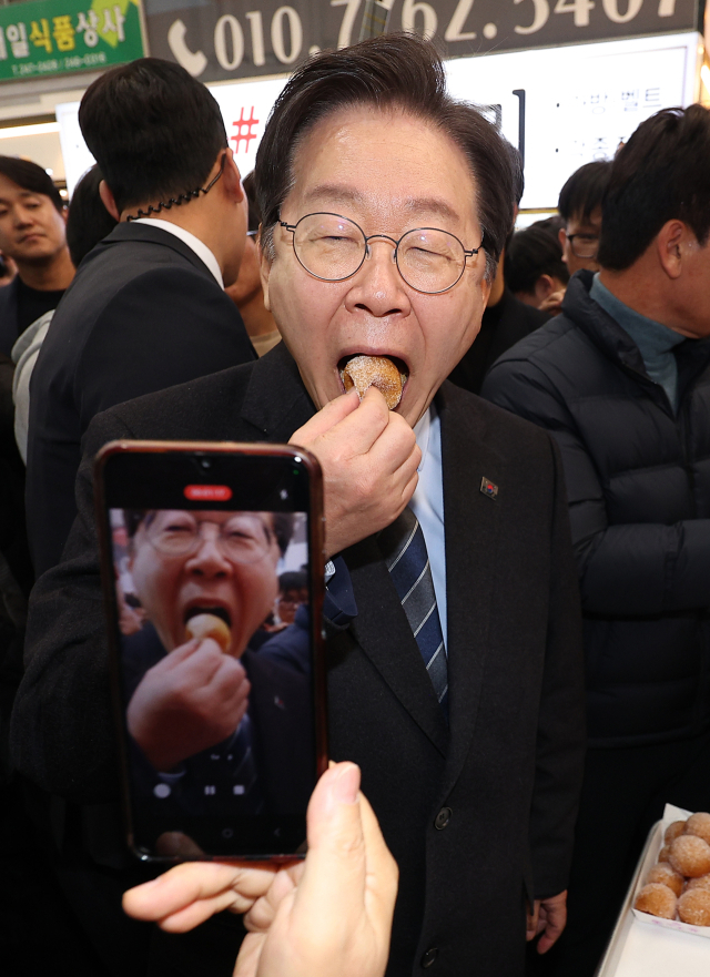 더불어민주당 이재명 대표가 1일 오후 경북 포항시 죽도시장을 찾아 찹쌀도넛을 먹고 있다. 연합뉴스