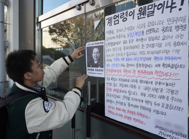 비상계엄 사태에 대학가에서 정권 비판 목소리가 나오고 있다. 4일 오후 경북대 교정에서 한 학생이 윤 대통령 탄핵을 촉구하는 대자보를 붙이고 있다. 김영진 기자 kyjmaeil@imaeil.com