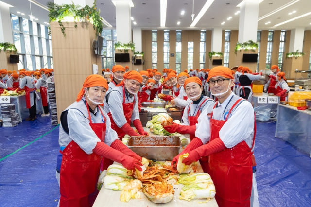함진규(오른쪽) 한국도로공사 사장이 지난 5일 사랑의 김장 담그기 행사에서 임직원들과 사진을 찍고 있다. 한국도로공사 제공