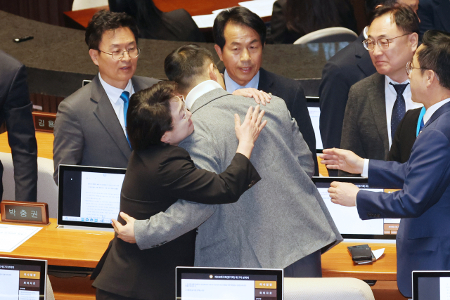 국민의힘 김상욱 의원이 7일 오후 국회 본회의에서 윤석열 대통령의 탄핵소추안에 대한 표결에 동참한 뒤 조국혁신당 김선민 의원 등 야당 의원들의 격려를 받고 있다. 연합뉴스