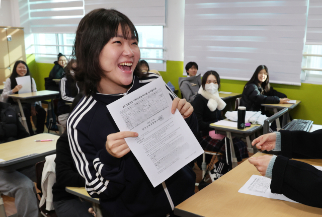 2025학년도 대학수학능력시험 성적표가 배부된 6일 오전 부산 동래구 사직여자고등학교 3학년 교실에서 한 학생이 선생님으로부터 수능 성적표를 받고 기뻐하고 있다. 연합뉴스