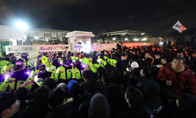 국회가 비상계엄 해제 요구 결의안을 가결한 지난 4일 새벽 국회 앞에서 시민들이 국회 출입을 통제하는 경찰과 대치하고 있다. 연합뉴스