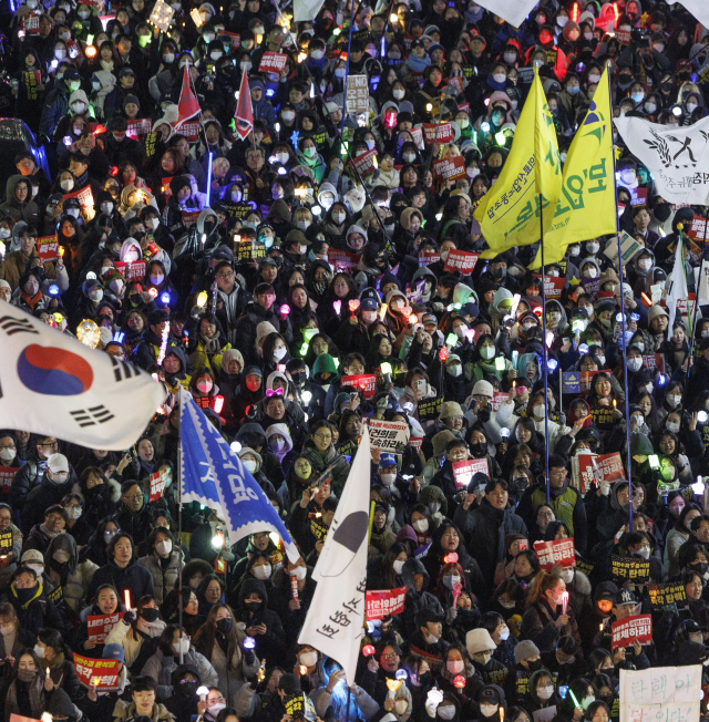 비상계엄 후폭풍이 계속되고 있는 11일 오후 서울 여의도 국회 앞에서 열린 윤석열 대통령 탄핵 촉구 촛불 집회 참가 시민들이 촛불과 응원봉을 들고 국민의힘 당사를 향해 행진하고 있다. 연합뉴스
